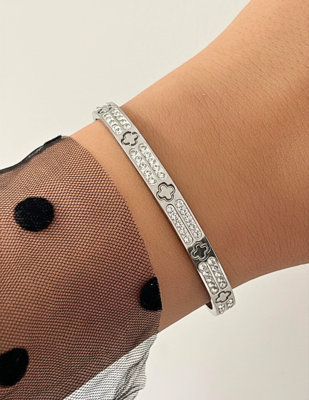 WRIST WEARNG GOLD BANGLE ON NEUTRAL BACKGROUND