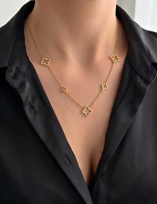 MODEL WEARING BLACK SHIRT AND GOLD PLATED CLOVER NECKLACE 