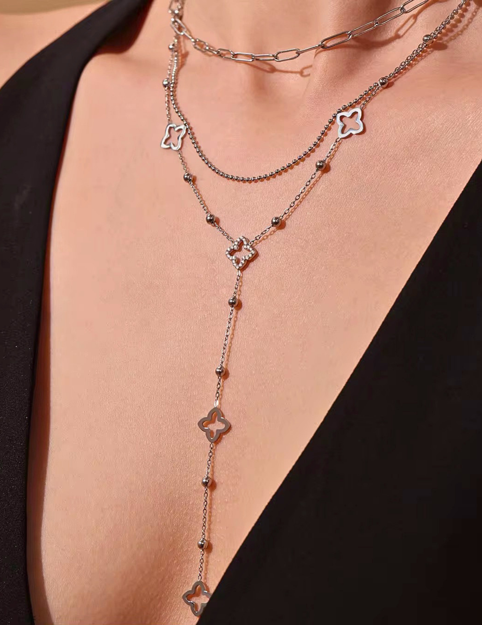 WOMAN WEARING LONG SILVER CLOVER NECKLACE 