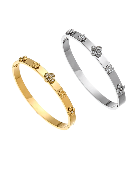 A GOLD PLATED CLOVER BANGLE AND SILVER CLOVER BANGLE ON WHITE BACKGROUND