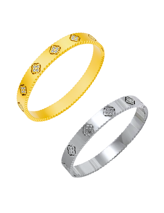 A GOLD PLATED CLOVER BANGLE AND SILVER BANGLE ON WHITE BACKGROUND