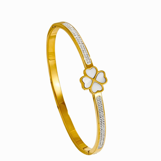 Gold bracelet with a clover-shaped charm on a white background
