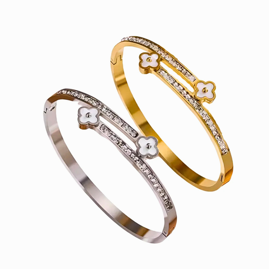 Two gold and silver bangles with floral designs on a white background