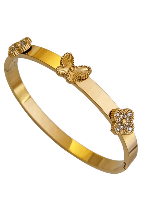 Gold bracelet with butterfly and floral designs on a white background