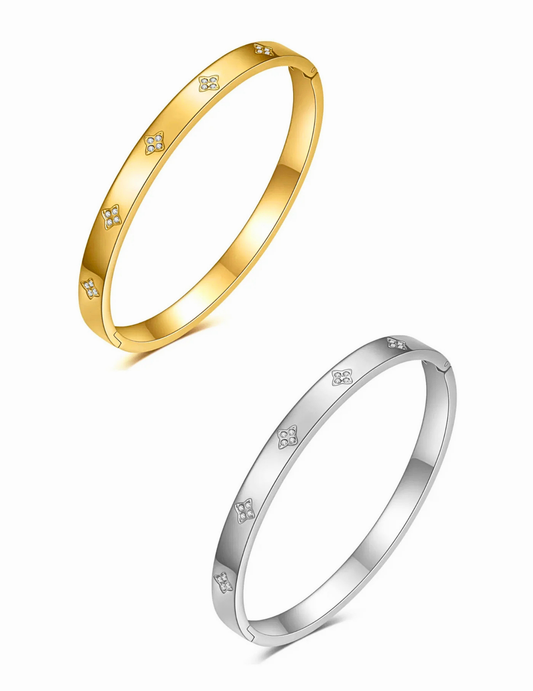 Gold and silver bangles with small diamond-like stones on a white background