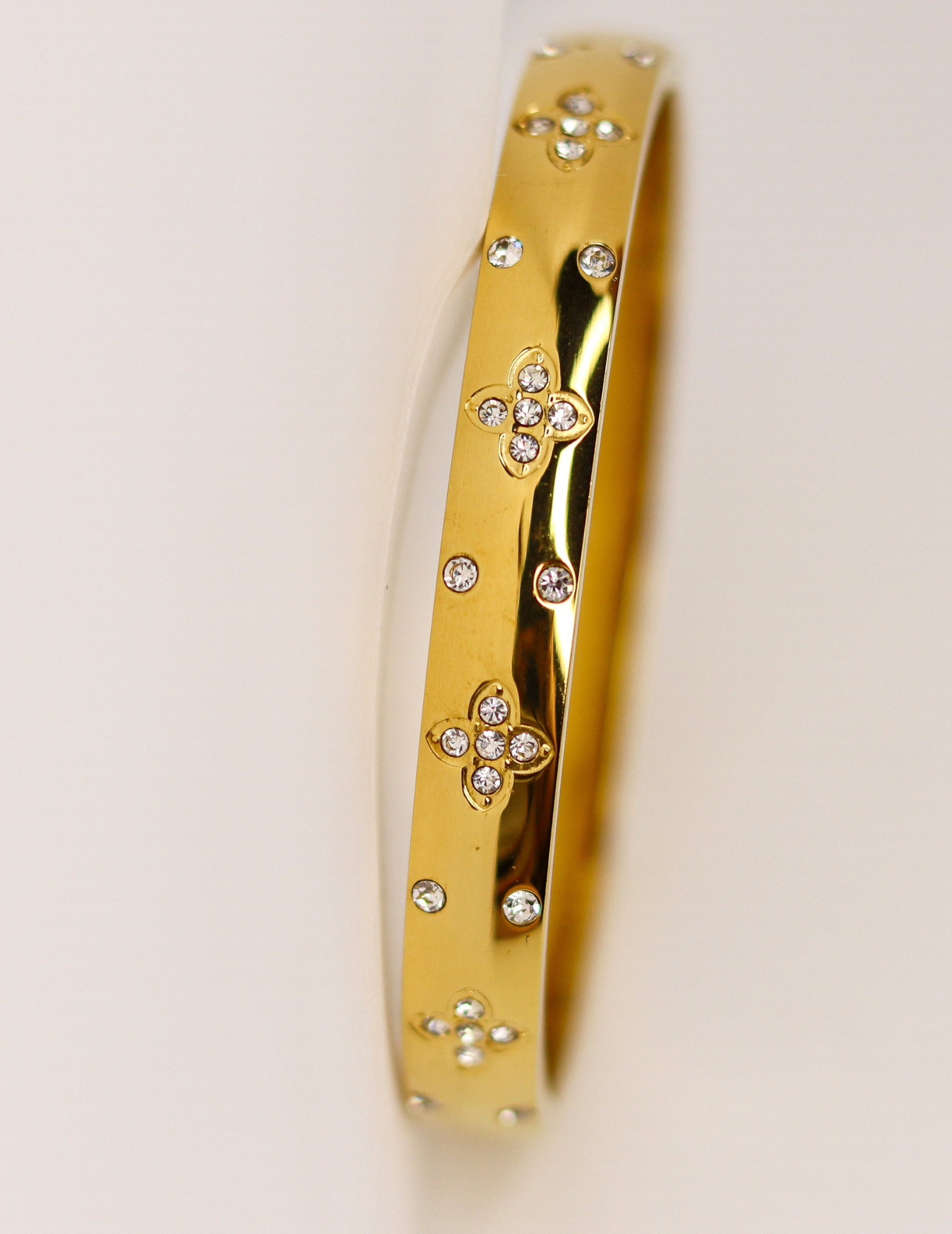 gold floral clover bangle on neutral background