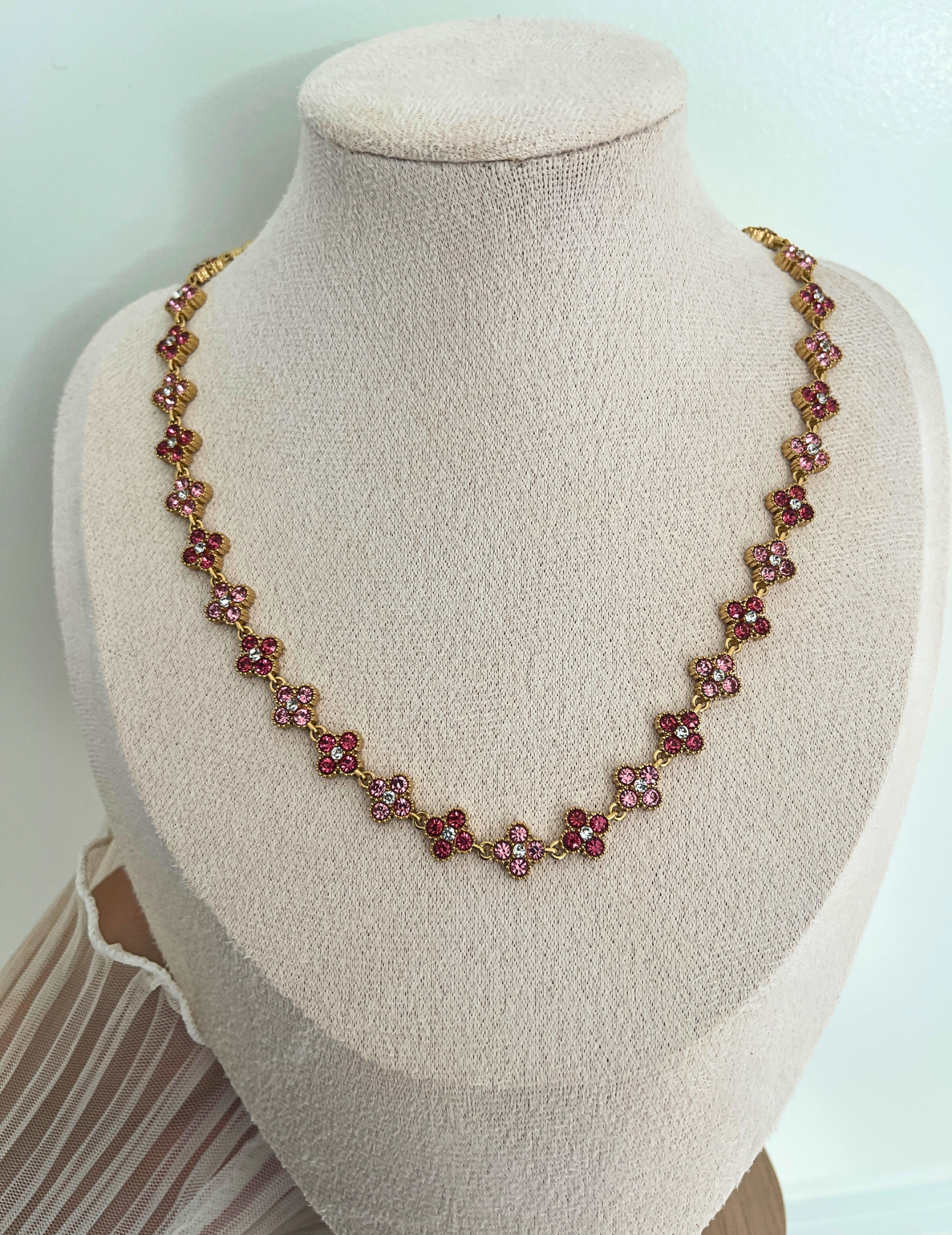 pink clover necklace on neutral background