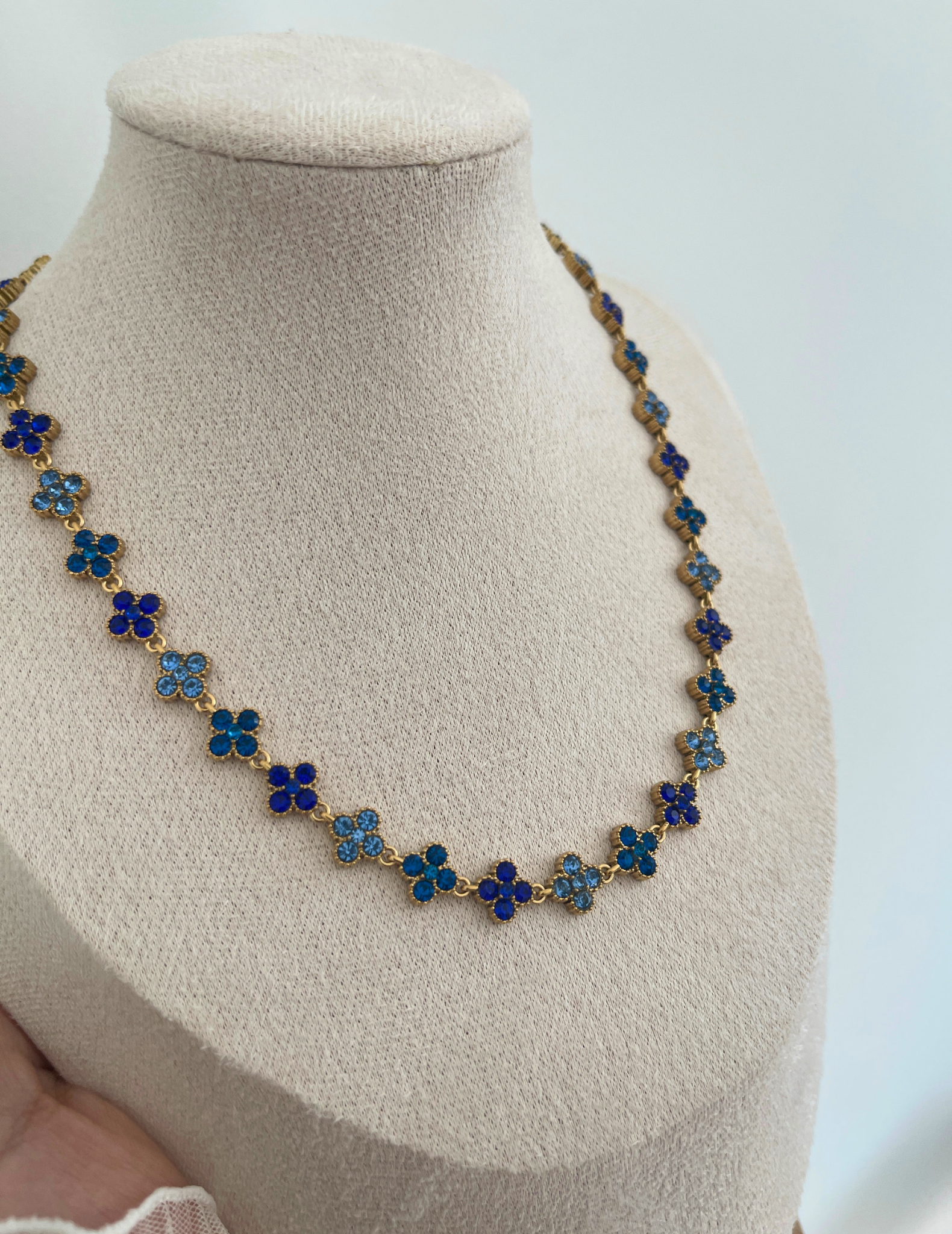blue clover necklace on neutral background