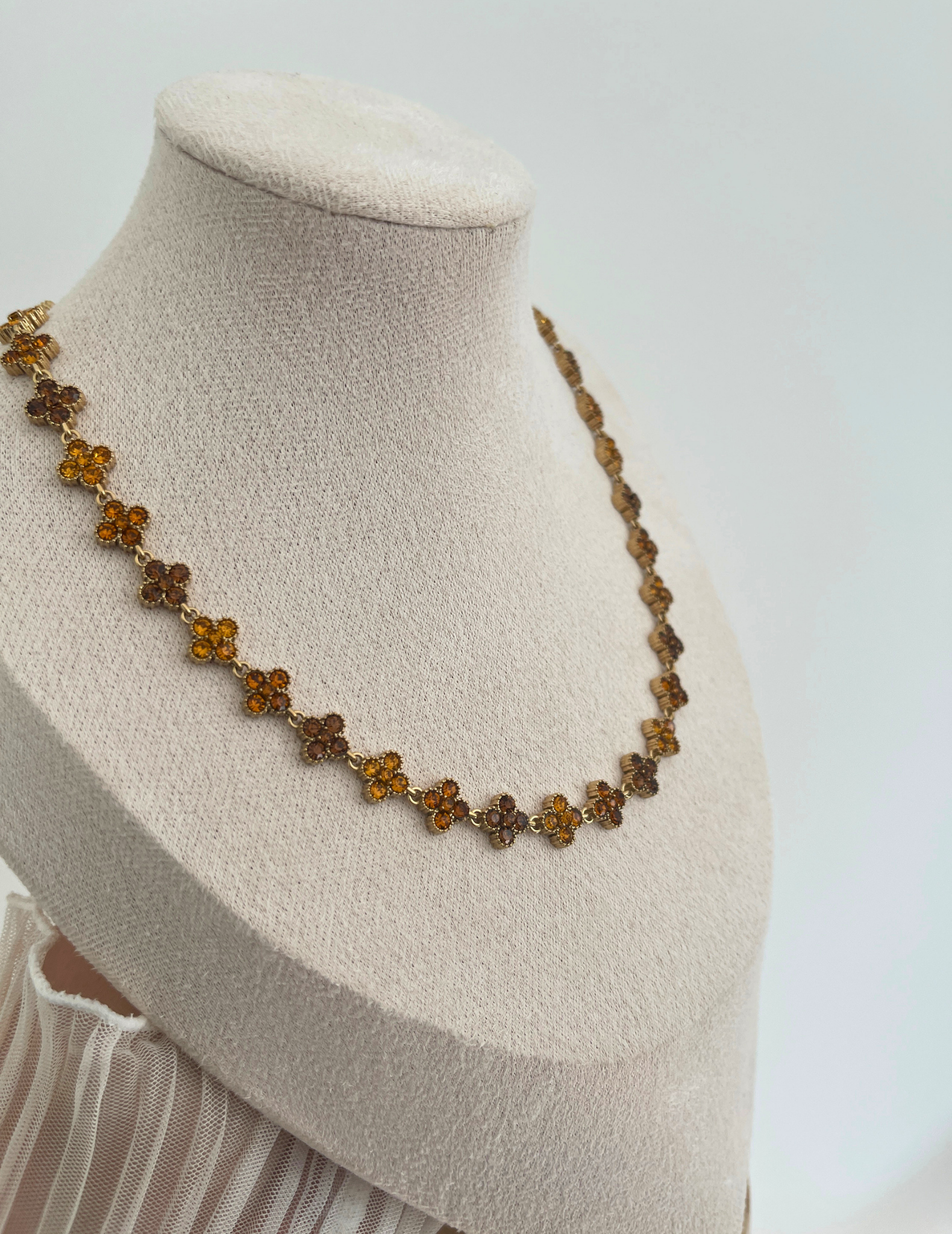 brown clover necklace on neutral background