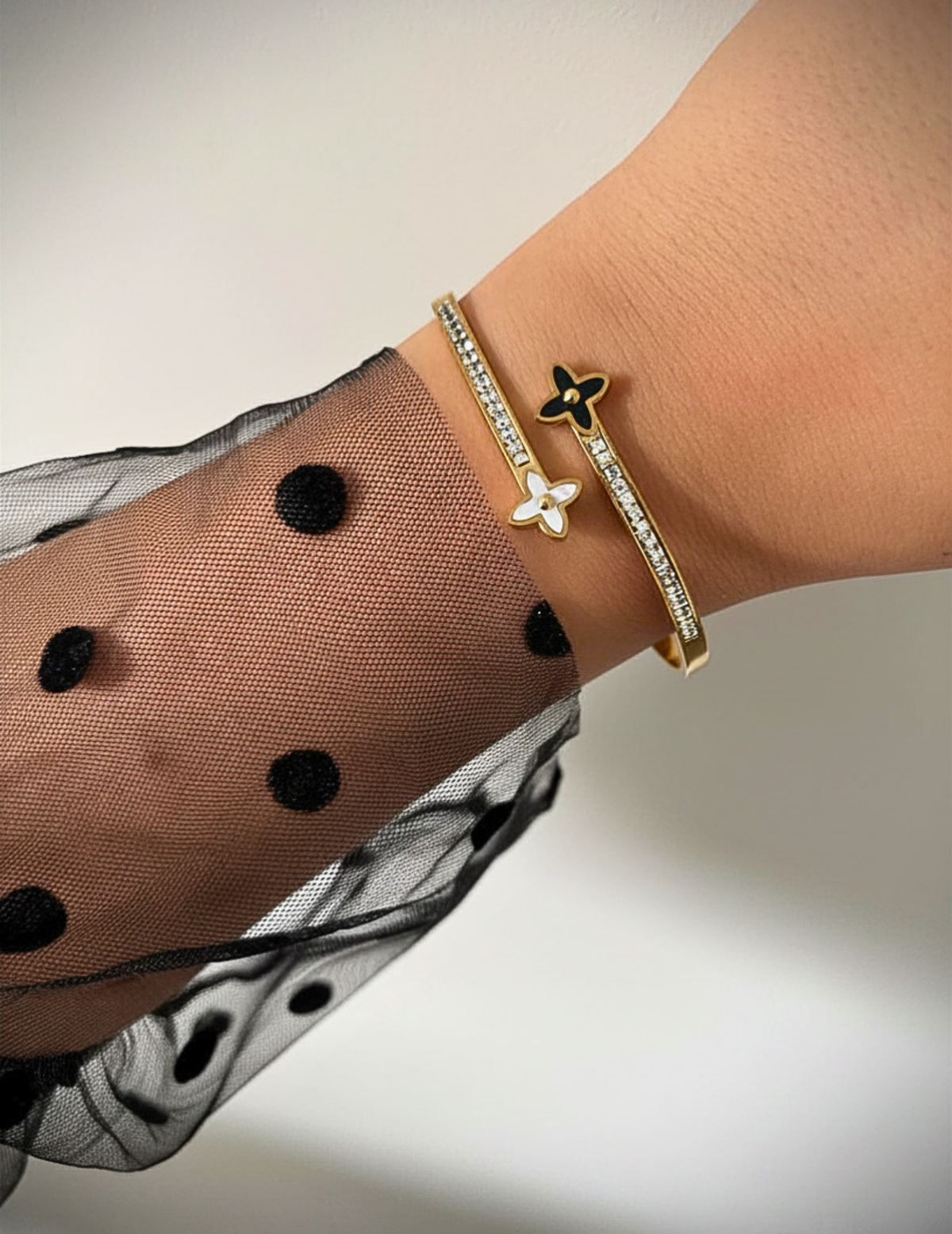WRIST WEARNG GOLD BANGLE ON NEUTRAL BACKGROUND