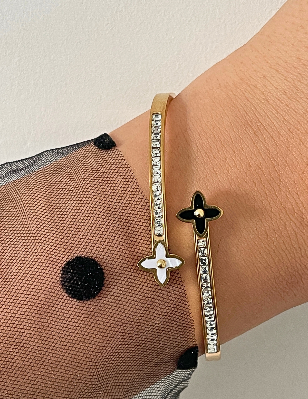 WRIST WEARNG GOLD BANGLE ON NEUTRAL BACKGROUND