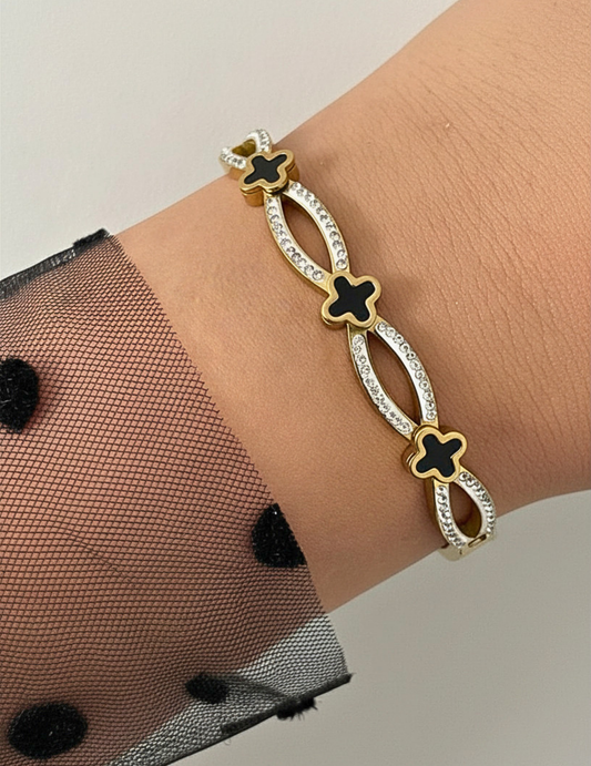 WRIST WEARNG GOLD BANGLE ON NEUTRAL BACKGROUND