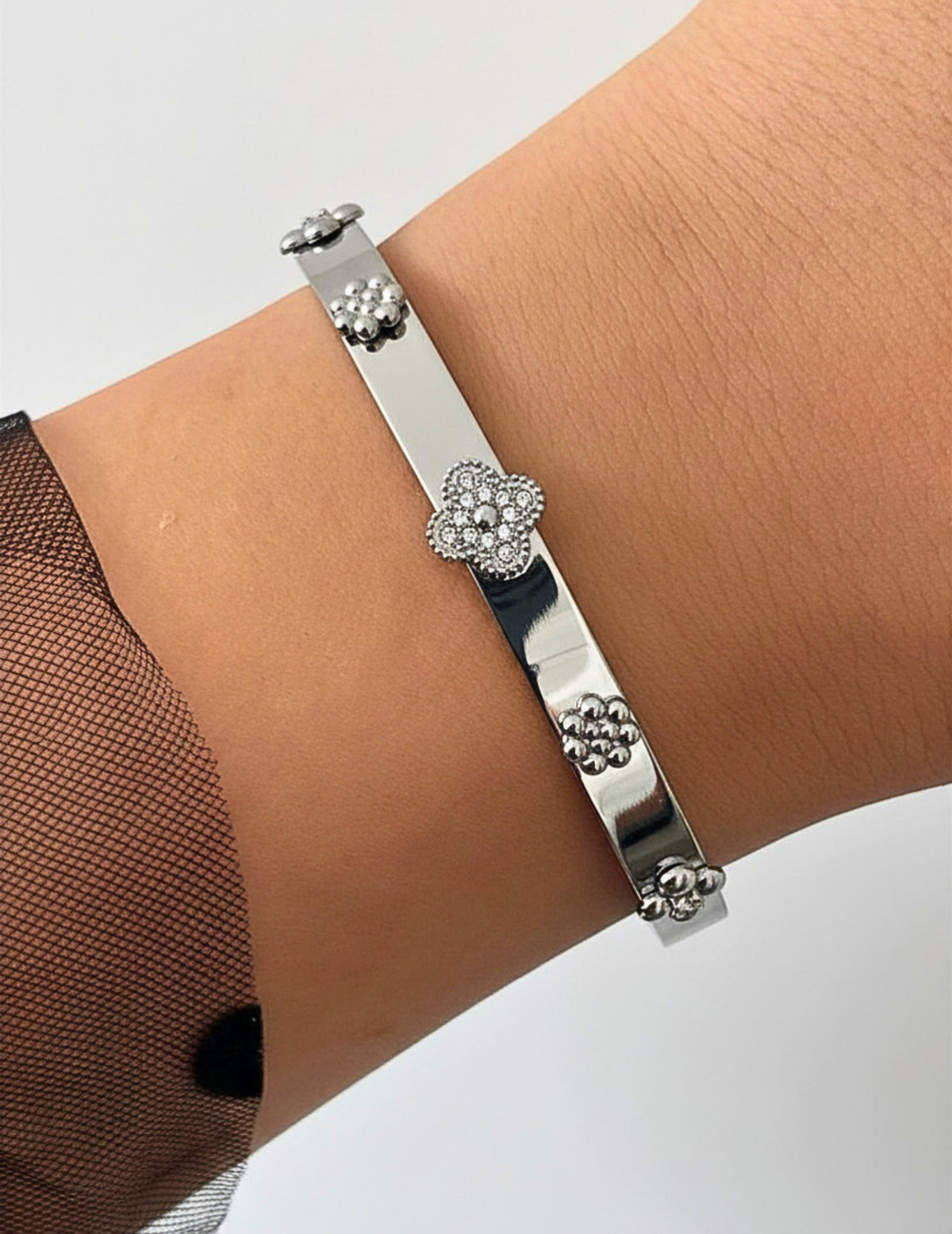 WRIST WEARNG SILVER BANGLE ON NEUTRAL BACKGROUND