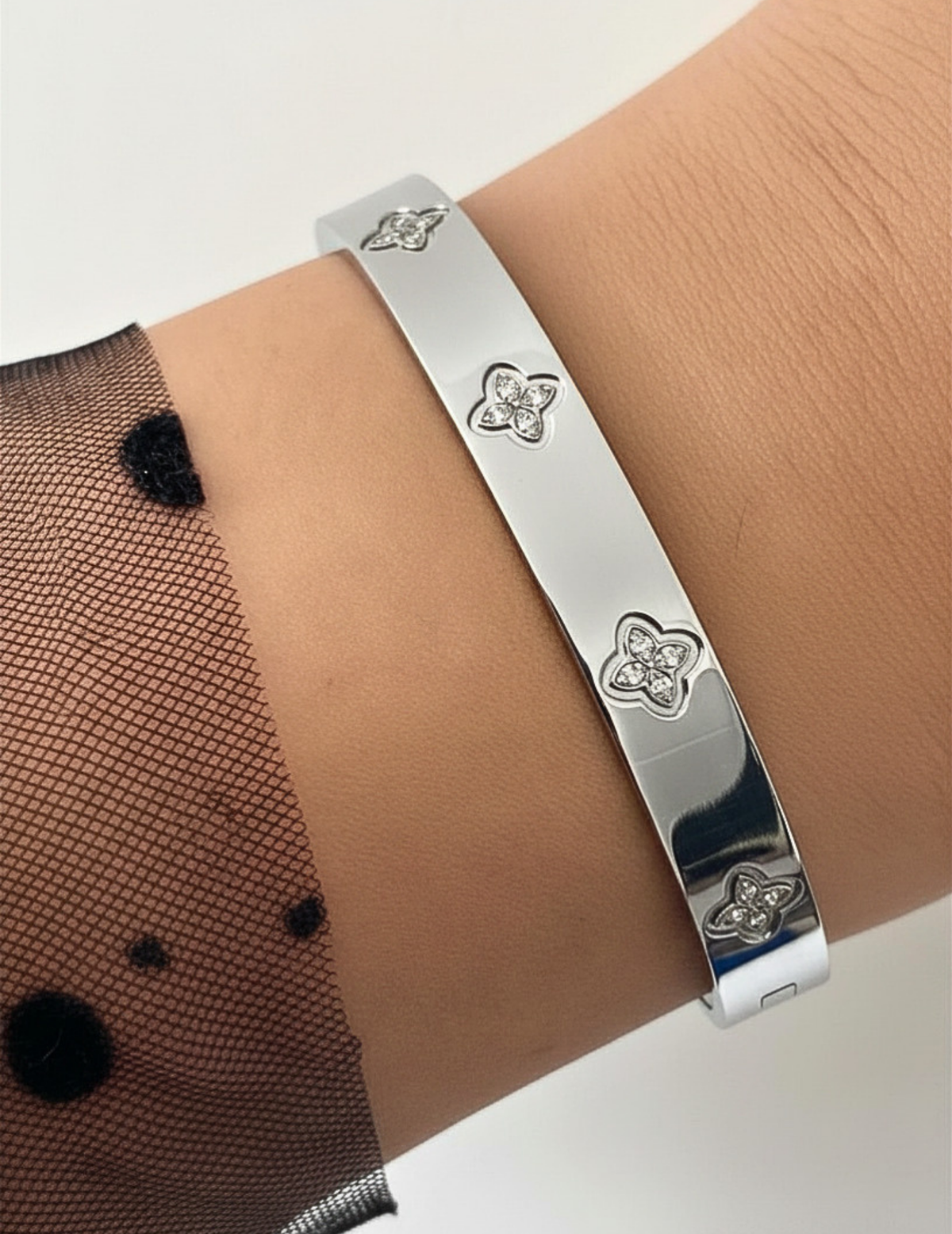 WRIST WEARNG SILVER BANGLE ON NEUTRAL BACKGROUND