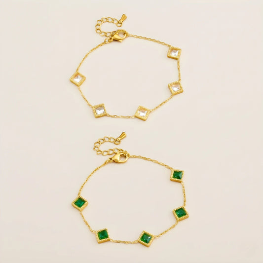 18k Gold on stainless steel bracelet with green gemstones on a beige background