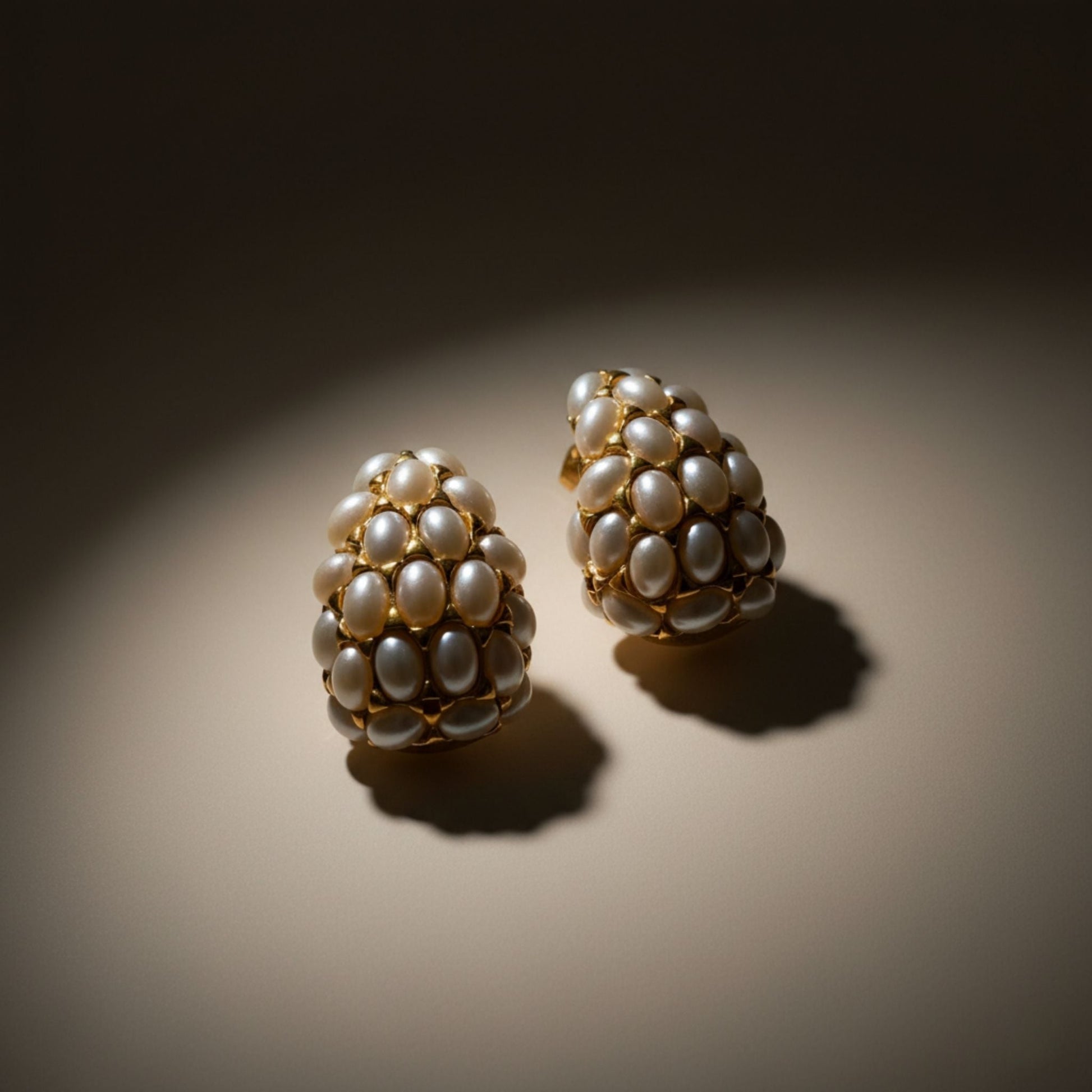 Pair of pearl gold earrings on a dark background